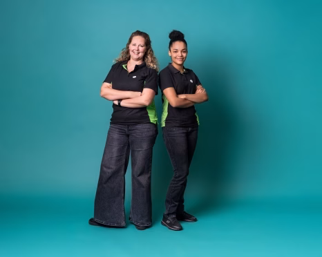 Two women in black on teal background - Getec Emmen - GETEC