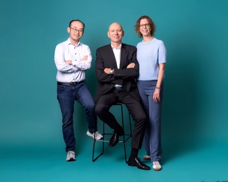 Three people posing in teal studio set - GETEC Hamburg 04023 - GETEC